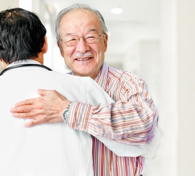 A person smiling while hugging a doctor